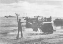 COAST GUARDSMAN DIRECTS TRAFFIC AS LANDING CRAFT, MANNED BY COAST GUARD CREWS BRING IN STREAMS OF SUPPLIES TO THE AMERICAN BASE OF GUADALCANAL
